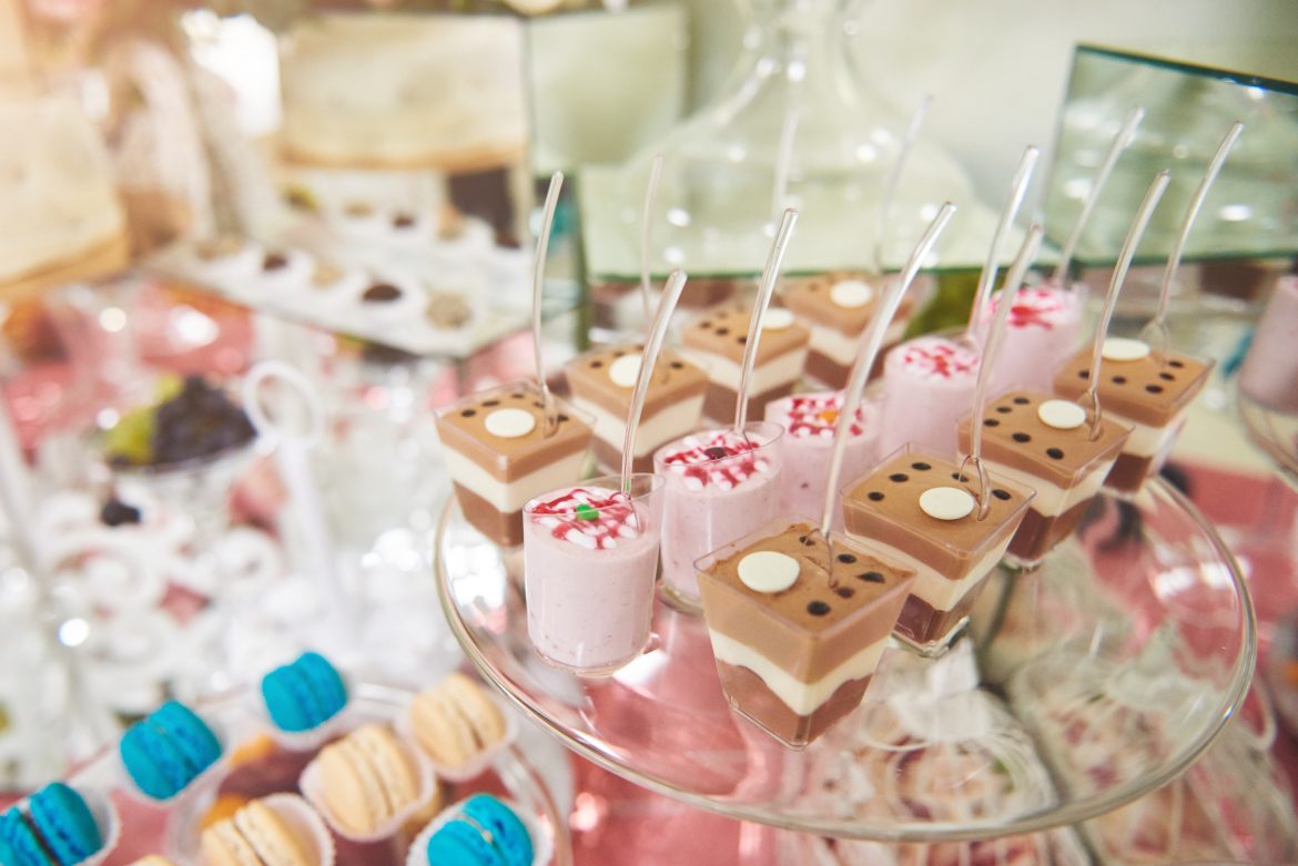 Dessert cups with chocolate and strawberry mousse by a catering service, elegantly displayed for a baptism event.