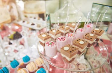 Dessert cups with chocolate and strawberry mousse by a catering service, elegantly displayed for a baptism event.